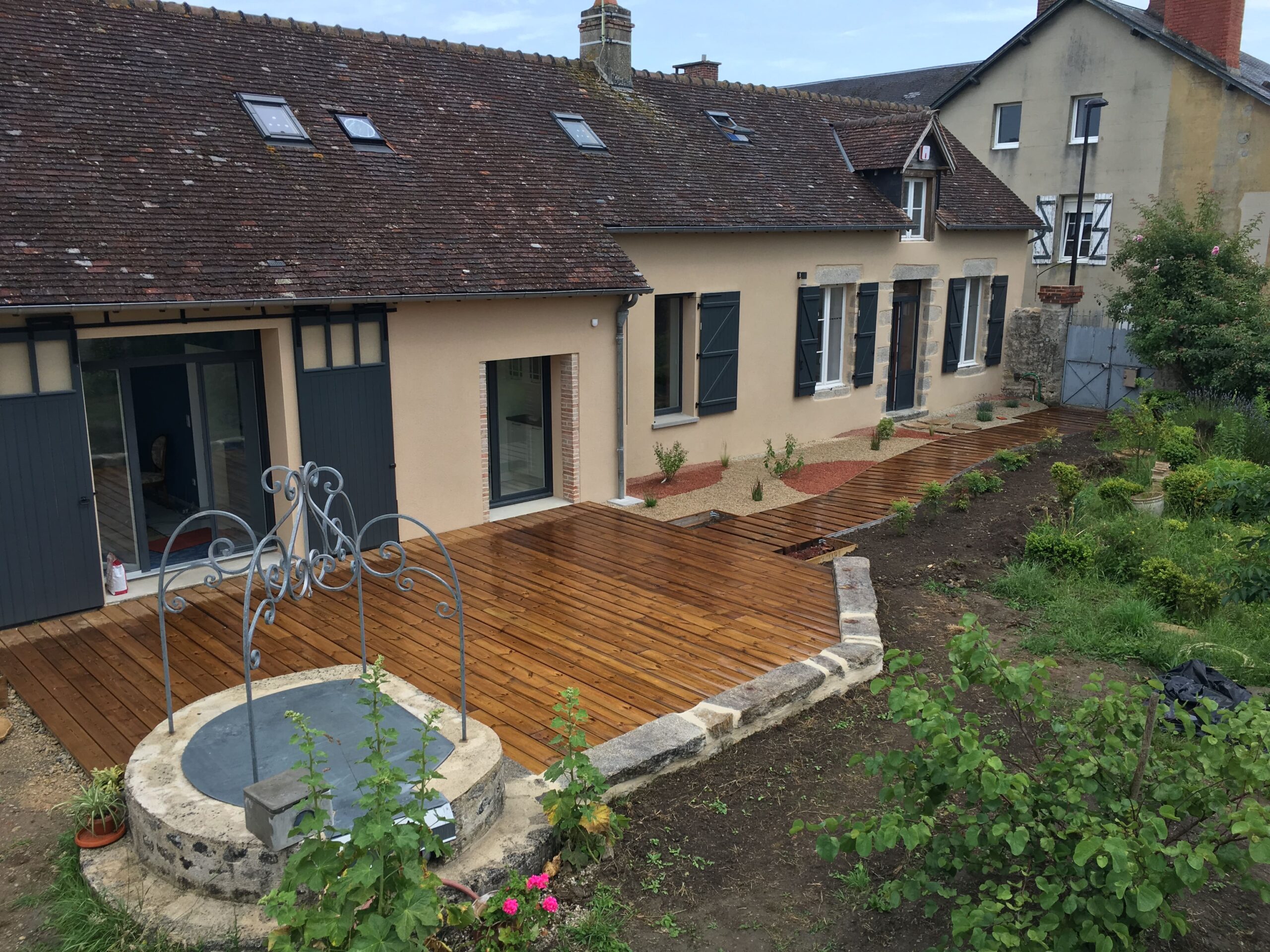 Terrassement et aménagement d'une longère, incluant la préparation du terrain, le nivellement, l'excavation pour les fondations et l'aménagement extérieur tel que la création d'allées, de terrasses et de jardins.