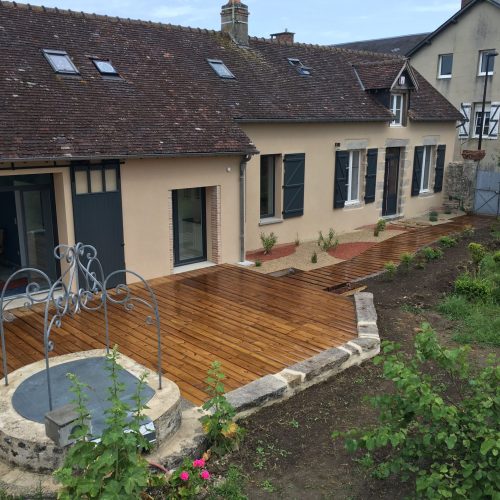 Terrassement et aménagement d'une longère, incluant la préparation du terrain, le nivellement, l'excavation pour les fondations et l'aménagement extérieur tel que la création d'allées, de terrasses et de jardins.